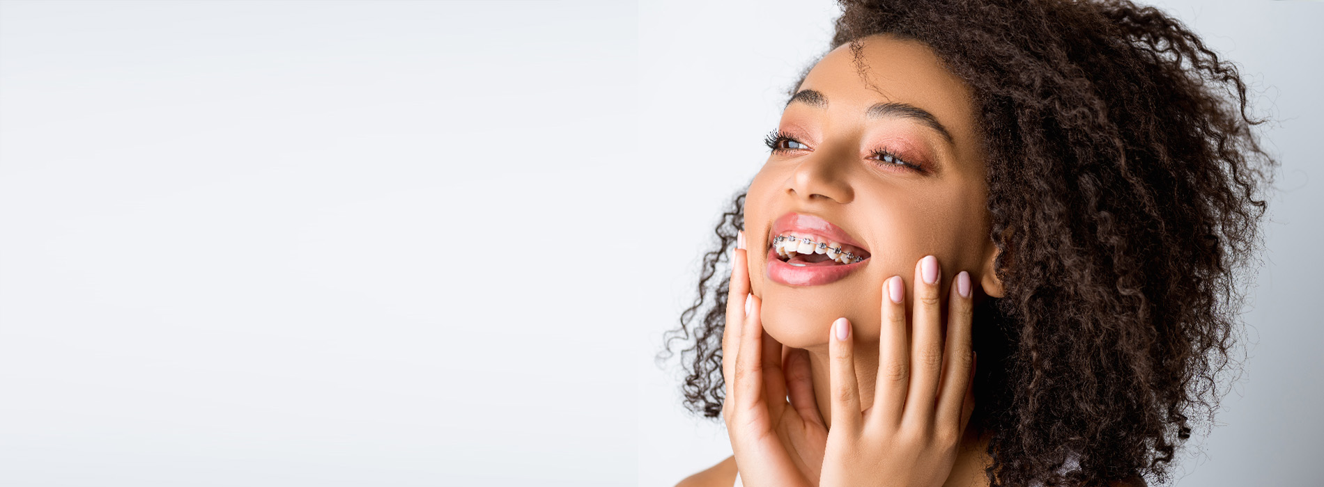 The image shows a person with their eyes closed, holding their face with both hands, possibly in the midst of a skincare or beauty routine.